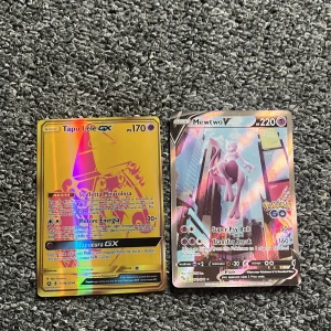 Pokémonkort: Tapu Lele GX & Mewtwo V - Två coola och glittriga Pokémonkort: Tapu Lele GX och Mewtwo V. Perfekt för dig som samlar eller vill boosta din lek med starka och snygga kort. Båda korten är i fint skick och redo för nya äventyr!