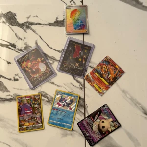 Pokémonkort - Blandade V och GX-kort - Samling av coola Pokémonkort med populära karaktärer som Charizard, Gengar, Drizzile och Mimikyu. Perfekt för dig som vill boosta din samling med färgstarka och sällsynta kort. Några kort är i skyddsfodral. Passar både samlare och spelare!