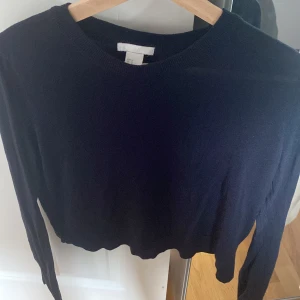 Svart stickad tröja från H&M - En svart, tunnstickad tröja från H&M i storlek M. Tröjan har rund halsringning, långa ärmar och en enkel, klassisk design som är lätt att matcha. Perfekt för lager-på-lager och funkar året runt.