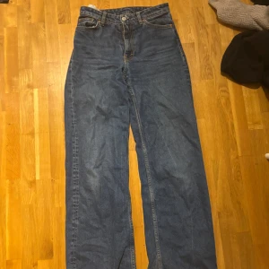 Blå raka jeans, midja 25 - Säljer ett par klassiska blå jeans med raka ben och hög midja. Jeansen har fem fickor, gylf med knapp och dragkedja samt snygga kontrastsömmar. Perfekta för dig som gillar en tidlös och avslappnad look.