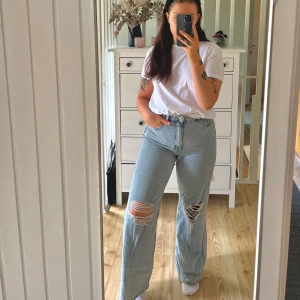 Wide jeans H&M - Säljer ett par skitsnygga ljusblå wide jeans från H&M i 100% bomull. De har hög midja, raka och vida ben samt snygga slitningar över båda knäna.  Något små i storlek!🌸