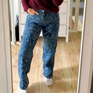 Unika jeans från H&M - Säljer ett par så coola blå jeans från H&M med unikt swirlmönster i olika blå nyanser. Byxorna har raka ben, klassiska fickor och är tillverkade i 100% bomull. Använda en gång!☀️Något lite små i storleken!