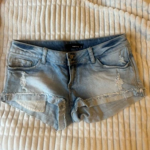 Lågmidjade jeansshorts Tally Weijl - Snygga ljusblå jeansshorts från Tally Weijl med låg midja och slitna detaljer. Storlek S-M!