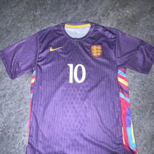 Lila England Bellingham fotbollströja - Snygg lila England fotbollströja från Nike med Bellingham och nummer 10 på ryggen.