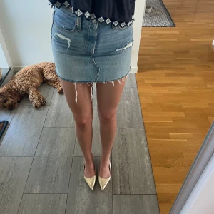 Levi's ljusblå jeanskjol med fransar🩵 - Ljusblå jeanskjol från Levi's med råa, fransiga kanter och slitna detaljer framtill. Klassisk femficksmodell med dragkedja och knapp. Perfekt för dig som gillar en avslappnad och trendig stil.🩵 nypris 600kr