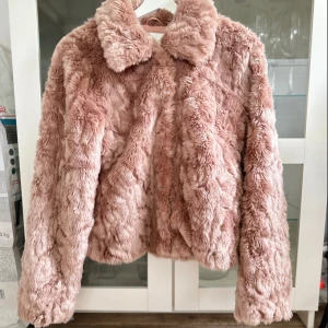 Rosa fluffig jacka - En rosa Perlo pälsimitation jacka i storlek 38 från VILA som är använd ett fåtal gånger. Köptes för 499kr! FÖRST TILL KVARN!