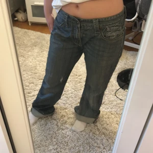 QB Denim blå jeans bootcut 32/32 - Säljer ett par blå bootcut jeans från QB Denim i storlek 32/32. Jeansen har klassisk femficksdesign, snygga detaljer på bakfickorna och uppvikta benslut. Materialet är slitstarkt denim i bomull och passformen är loose med bredare ben.