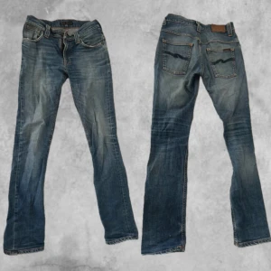 Faded jeans från Nudie Jeans - Storlek 30 midja, kom med bud. Säljer ett par klassiska blå jeans från Nudie med bootcut passform. Jeansen har snygga slitningar, fem fickor och Nudie-logga på bakfickan. Perfekta för dig som gillar en avslappnad men ändå stilren look. 