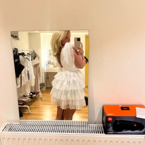 Vit volang klänning - Extremt fin volangklänning som det var tänkt till att jag skulle ha på min student. Men det blev tyvärr inte så. Har sytt om klänningen lite vid axlarna. Klänningen är i storlek L men passa mig som är en M