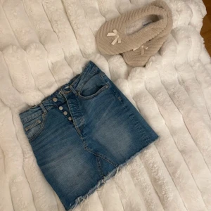 Jeanskjol från Perfect Jeans - GinaTricot - Snygg jeanskjol från Gina i klassisk blå denim. Kjolen har en kort längd med fransig nederkant och knappar framtill. Perfekt för en avslappnad stil.