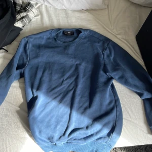 Blå sweatshirt från H&M - Säljer en blå sweatshirt från H&M i storlek XS. Tröjan har en rund halsringning och är tillverkad i ett mjukt material för en avslappnad passform. Perfekt för en casual look.