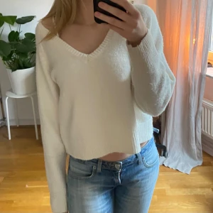 Vit stickad tröja från BikBok - Säljer en vit stickad tröja från BikBok med v-ringning. Tröjan har långa ärmar men croppad. Superfin men kommer inte till användning💕