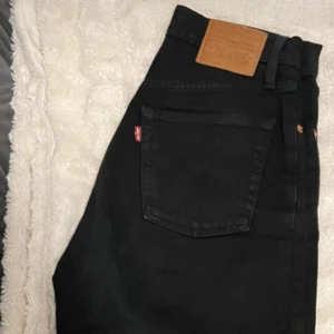 Svarta jeans från Levi's - Säljer ett par svarta Levi's Ribcage Straight jeans. De har en mellan/hög midja och raka ben, vilket ger en klassisk look. Perfekta för dig som gillar en stilren och tidlös stil. 🖤W25 L29