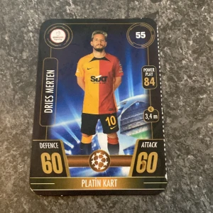 Fotbollskort med Dries Mertens - Fotbollskort med Dries Mertens i gul och röd matchtröja. Kortet har värden som Power Play 84, Defence 60 och Attack 60. Det är märkt som 'Platin Kart' och har en prissymbol på 3,4 miljoner euro.