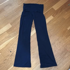 Marinblå byxor från Gina Tricot - Snygga mörkblå yogapants från Gina Tricot med en elegant och enkel design. Byxorna har en rak passform och är perfekta för en stilren look. De är tillverkade i ett mjukt och bekvämt material.