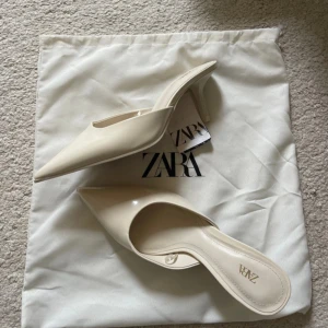 Klackskor från Zara - Snygga cremfärgade klackskor från Zara med spetsig tå och öppen häl. Aldrig använda. Prislappen finns men är inte fast på skorna. De finns inte i sortiment längre.