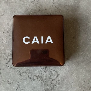 CAIA Glow Bronzer La Digue - Snygg bronzer från CAIA i nyansen La Digue. Kommer i en stilren brun förpackning med spegel inuti. Perfekt för att ge ansiktet en solkysst look med en fin lyster.