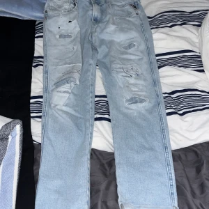 Ljusa jeans från Replay - Säljer ett par ljusa jeans från Replay med slitna detaljer. De har en klassisk femficksdesign och en bekväm passform. Perfekta för en avslappnad stil. Köpta för 1000 kr. Säljs pga försmå. Lite mindre i storlek men de märks inte att dom är mindre i storlek 