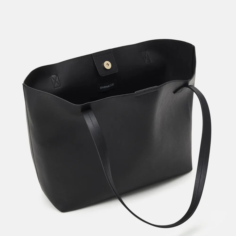 Snygg svart axelväska i skinn med en matchande liten plånbok. Väskan har en enkel och stilren design med långa axelremmar och en knappstängning. Perfekt för att bära med sig det nödvändigaste med stil.. Laukut & Käsilaukut.