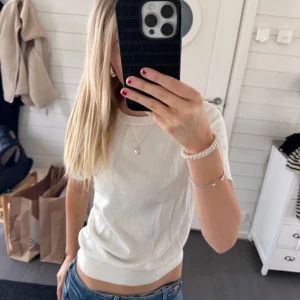 Vit kortärmad topp💋 - Säljer en stilren vit kortärmad topp. Perfekt för en enkel och fräsch look. Toppen har en rund halsringning och är gjord i ett mjukt material.