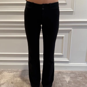 Svarta kostymbyxor från Esprit - Snygga svarta byxor från Esprit med en klassisk design. De har en normal passform och är perfekta för en stilren look. Byxorna har knappar framtill och är tillverkade i ett bekvämt material.