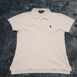 Ralph Lauren piké - Säljer en klassisk vit pikétröja från Ralph Lauren. Tröjan har korta ärmar och en broderad logotyp på bröstet.