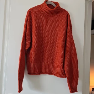 Orange stickad tröja från First Class - Säljer en snygg orange stickad tröja från First Class. Tröjan har en hög krage och långa ärmar, perfekt för kyliga dagar. Den är ribbad vid ärmslut och nederkant för extra komfort. Passar bra till både jeans och kjol. 🧡