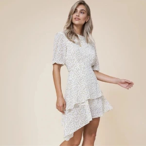 Asymmetrisk blommig kortklänning - Superfin kort klänning med asymmetrisk volangklännign från Adoore