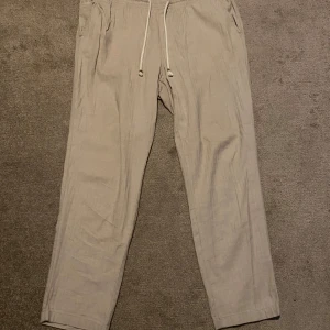Beige linnebyxor Jack & Jones XL - Ett par bekväma byxor med resår i midjan och dragsko. Är 185 och de sitter bra på mig. Använda 6-7 gånger, tvättade i efterhand. 