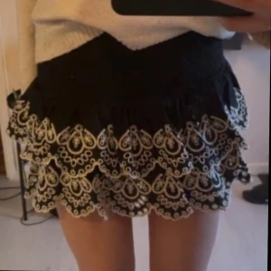 Svart kjol med broderi💝 - Supersöt svart kortkjol med vita broderier🤍 strl 170 men passar xs/s. Jättefint skick och knappast använd💕💕 populär, men säljs inte längre!!