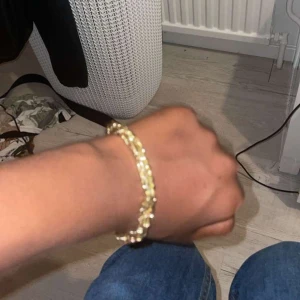 18 karat guld länk - Snyggt armband i guldton med kedjeliknande design som ger en lyxig känsla. Perfekt accessoar för att lyfta din outfit och ge lite extra bling till handleden. Passar dig som gillar stilrena men ändå iögonfallande smycken.