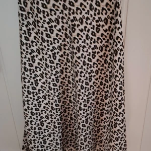 Leopardmönstrad kjol från Kilky Paris - Snygg leopardmönstrad kjol från Kily Paris i en bekväm passform. Kjolen har ett trendigt mönster som ger en djärv look. Perfekt för att addera lite vild stil till din garderob. Silk material och nyskick!
