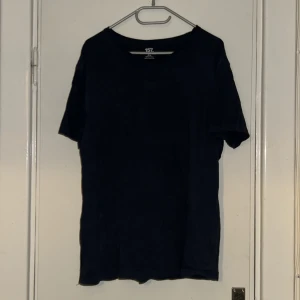 Mörkblå t-shirt från Lager 157  - En basic mörkblå t-shirt från Lager 157. Klassisk rund halsringning och korta ärmar. Perfekt för dig som gillar en enkel och stilren look. Passar dig som vill ha en lite större och loose fit.