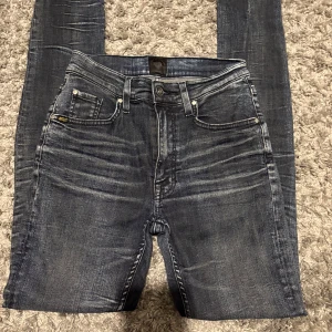 Tiger of Sweden jeans - Snygga mörkblå jeans med slitna detaljer och klassisk femficksdesign. Jeansen har en slim passform och är tillverkade i stretchig denim för extra komfort. Perfekta för dig som gillar en modern och stilren look.