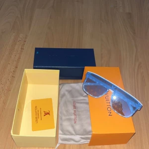  Vita solglasögon - Snygga vita solglasögon med blåtonade glas och ikoniskt monogram över hela linsen. Ramen är kraftig och har en modern, kantig form. Kommer med originalbox, fodral och certifikat. Perfekt accessoar för att sticka ut i mängden.