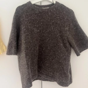 Brun stickad tröja från Gina Tricot - Mysig brun stickad tröja från Gina Tricot med kortare ärmar och rund hals. 