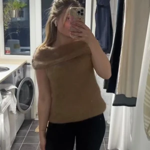 Beige stickad offshoulder topp - Säljer en beige stickad topp med offshoulder-design och bred krage. Mjuk och fluffig känsla, perfekt för dig som vill ha något unikt och mysigt. Snygg att styla med både jeans och kjol. Prislappen är kvar och inte använd någon gång!