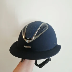 Marinblå ridhjälm Lamicell stl 57-61 - Storlek 57-61, justerbar. Endast använd i ett halvår 1 gång i veckan. Aldrig tappad eller avramlad i. Medföljer 1 extra liner.