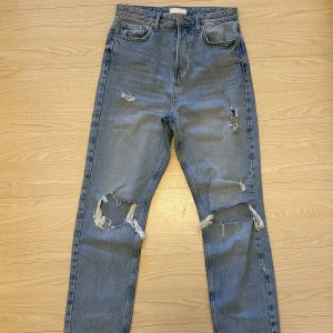 River Island jeans - Blå highwaist raka jeans med slitningar från River Island. UK strl - 10 (EU - 38) Använda fåtalet ggr.