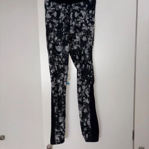 Nike Pro leggings svart/vit mönster - Nike Pro leggings med svart bas och vitt splattermönster. Tight passform och elastisk midja med logga. Perfekta för träning eller chill, tillverkade i stretchigt syntetmaterial som andas.