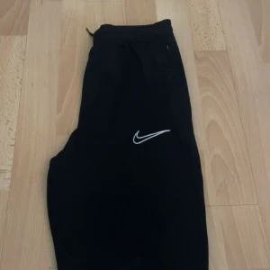 Nike träningsbyxor  - Säljer dessa Nike tränings byxor med vita sträck vid vaden. Säljer då de inte får någon användning och bara samlar damm. Nästan helt oanvända. 