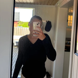 Svart stickad v-ringad tröja - Säljer en svart v-ringad tröja med lång ärm. Enkel och stilren modell som passar till mycket. Perfekt basplagg i garderoben.