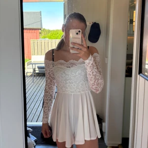 Vit spetsjumper med offshoulder och lång ärm - Säljer en superfin vit jumper med spets upptill och långa ärmar. Offshoulder-modell med romantisk känsla och flowig kjol. Perfekt för sommarens tillfällen. Lapparna sitter kvar på den