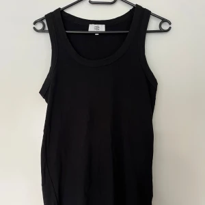 Noa Noa svart linne, storlek L - Svart ribbat linne med rund halsringning från Noa Noa. Storlek L. Mycket fint skick. 100% bomull.   Mått: Längd ca 59 cm Byst 45 cm Midja ca 48 cm