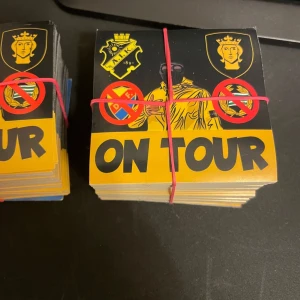 AIK On Tour klistermärken 30st - 7x7 cm. Säljer bunt med 30st AIK On Tour klistermärken. Motivet har AIK:s klubbmärke, en gulsvart figur med huva, Stockholms stadsvapen och texten 'ON TOUR' i svart på gul botten. Perfekt för att visa sitt stöd för AIK på resande fot. Obs! De är 7x7 cm 