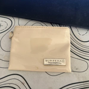 Burberry miniväska - En vintage burberry väska, oklart vad den är till men troligen någon typ av plånbok. Väldigt svår o hitta och sällsynt då den är vintage, denna är äkta! Kan gå för mer än 500 men kan inte så mycket om den