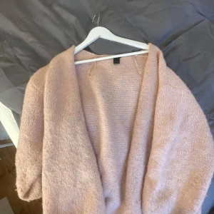 Rosa stickad kofta  - Mysig rosa stickad kofta från Lindex.(mer rosa i verkligheten) Koftan har lång ärm, öppen framtill och är tillverkad i ett mjukt, fluffigt material. Är lite sliten som ni ser på sista bilderna men inget man tänker på💗passar mindre storlek!! Jag brukar ha xs/S i koftor vanligtvis men vill ha lite oversize