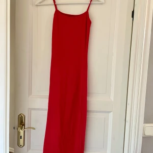 Röd långklänning med smala axelband - Säljer en röd långklänning med smala axelband och slits på sidan. I mycket bra skick!