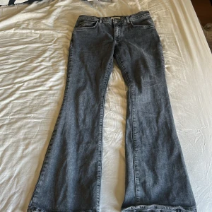 Grå bootcut jeans från Gina tricot - Säljer ett par gråa bootcut jeans från Perfect Jeans. Jeansen har klassisk femficksdesign, normal passform upptill och utsvängda ben. 