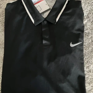 Nike Tiger Woods pikétröja NY - Från TW Collection som går ju inte längre att köpa :). Superkvalitet med snygga detaljer. 87% polyester, 13% spandex. Storlek M, men är stor i storleken, mer som L. Aldrig använts pga storleken. 